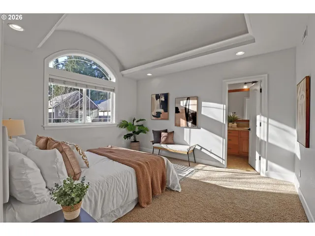 a bedroom with a bed mirror and window
