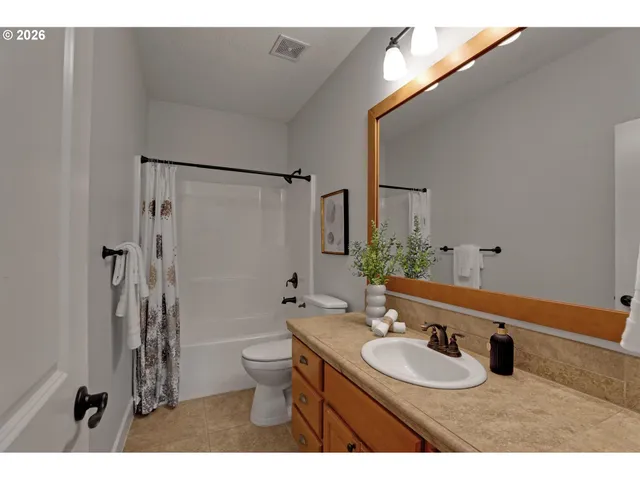 a bathroom with a sink toilet double vanity and shower