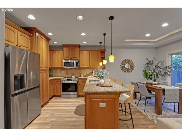 a kitchen with refrigerator a sink and chairs