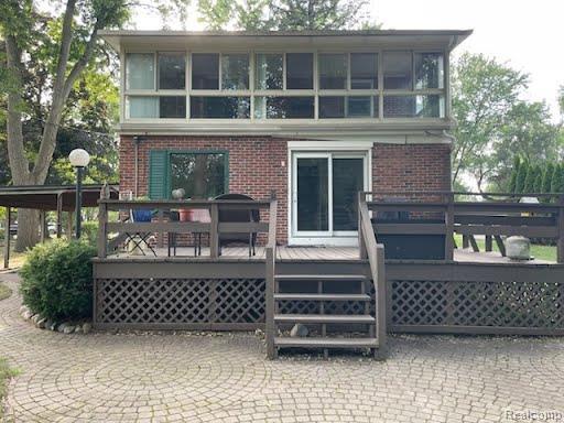 9552 Wayne Road Livonia, MI 48150 - Photo 25 of 31 Full view of the home’s rear exterior highlighting the expansive deck, enclosed upper porch, and attractive brick patio area.