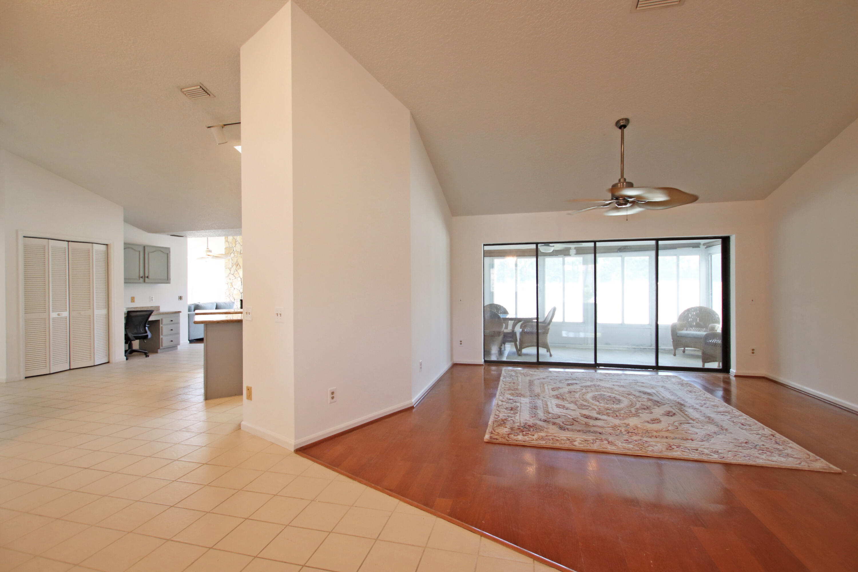 6944 Misty Lake Way Jupiter, FL 33458 - Photo 12 of 32 a view of a room with a chandelier and wooden floor