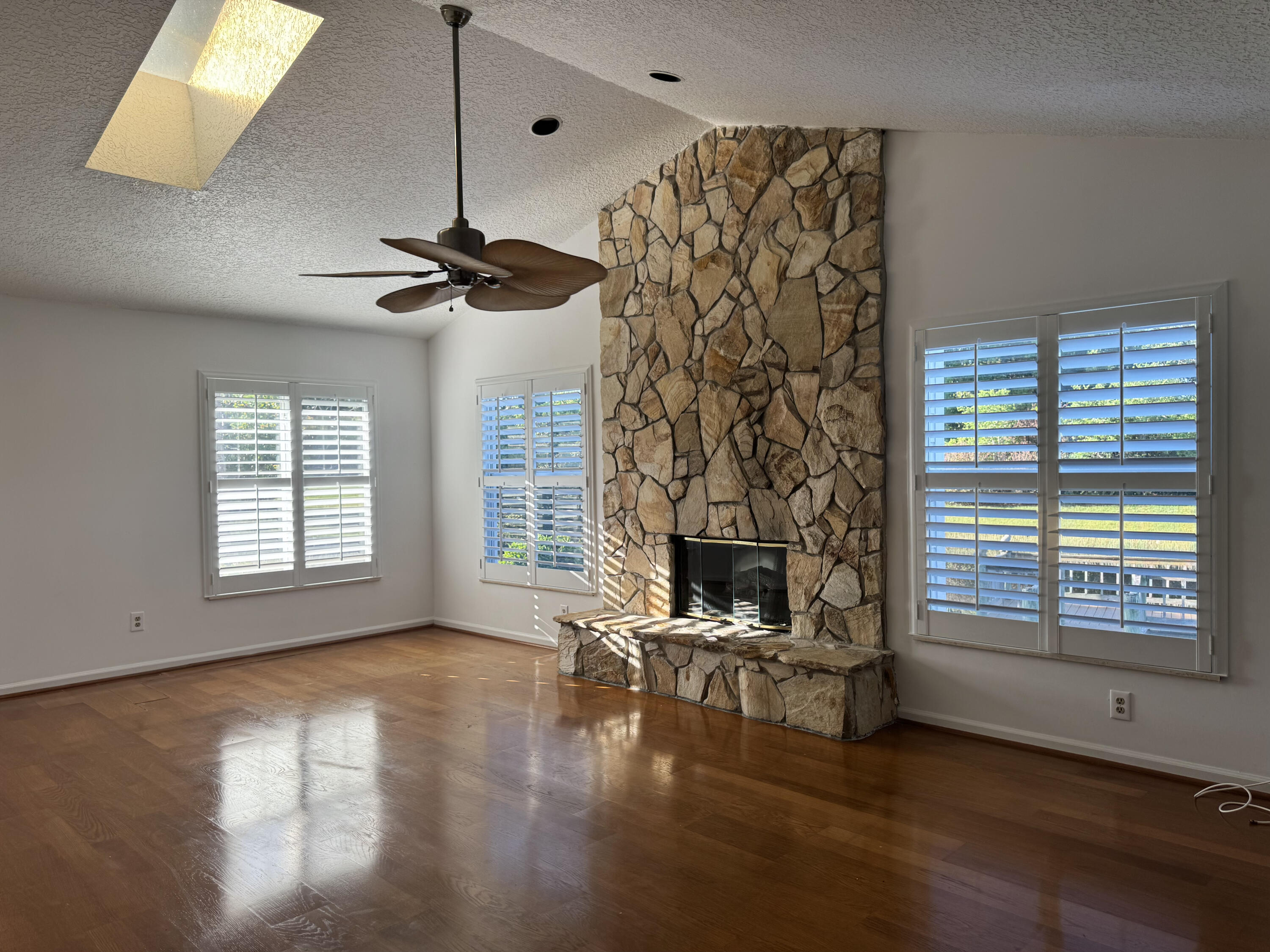 6944 Misty Lake Way Jupiter, FL 33458 - Photo 9 of 32 a view of a livingroom with a fireplace a ceiling fan and wooden floor