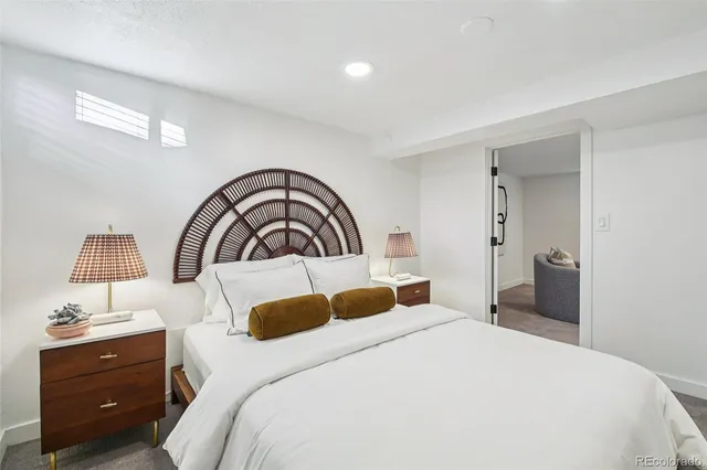 a bedroom with a bed and a lamp on dresser