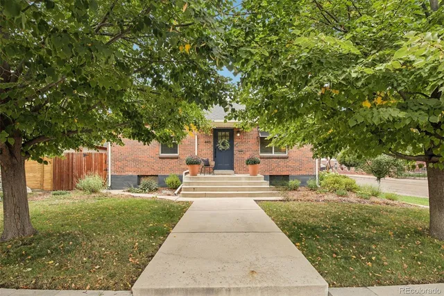 a front view of a house with a yard and trees