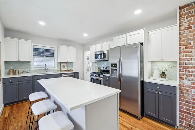 a kitchen with a refrigerator a stove a sink and cabinets
