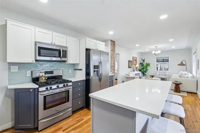 a kitchen with stainless steel appliances a stove a sink a microwave a refrigerator a stove and cabinets