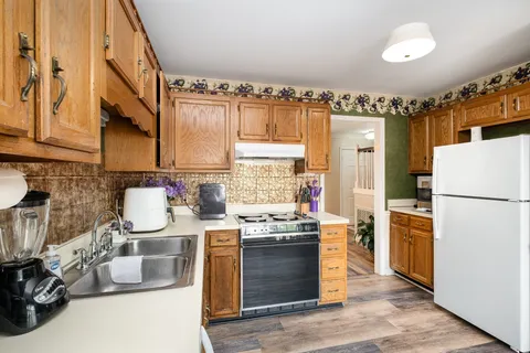 a kitchen with stainless steel appliances granite countertop a stove a sink and a refrigerator