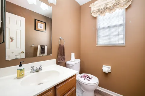 a bathroom with a sink vanity mirror and toilet