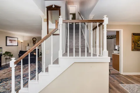 a view of staircase with railing and white walls