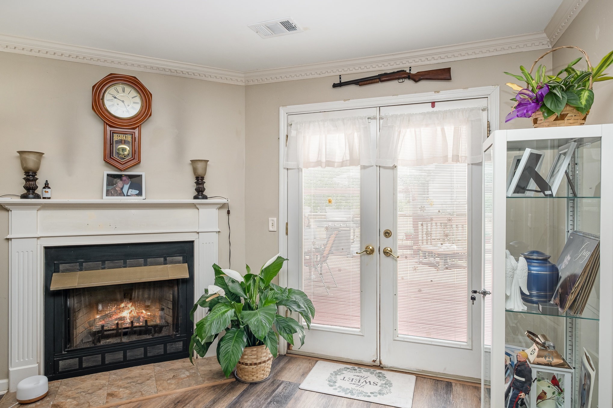 1113 Jacksons Valley Road Hermitage, TN 37076 - Photo 6 of 26 a living room with a fireplace a clock and a potted plant