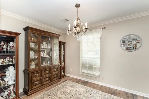 a view of a hallway view with wooden floor and chandelier