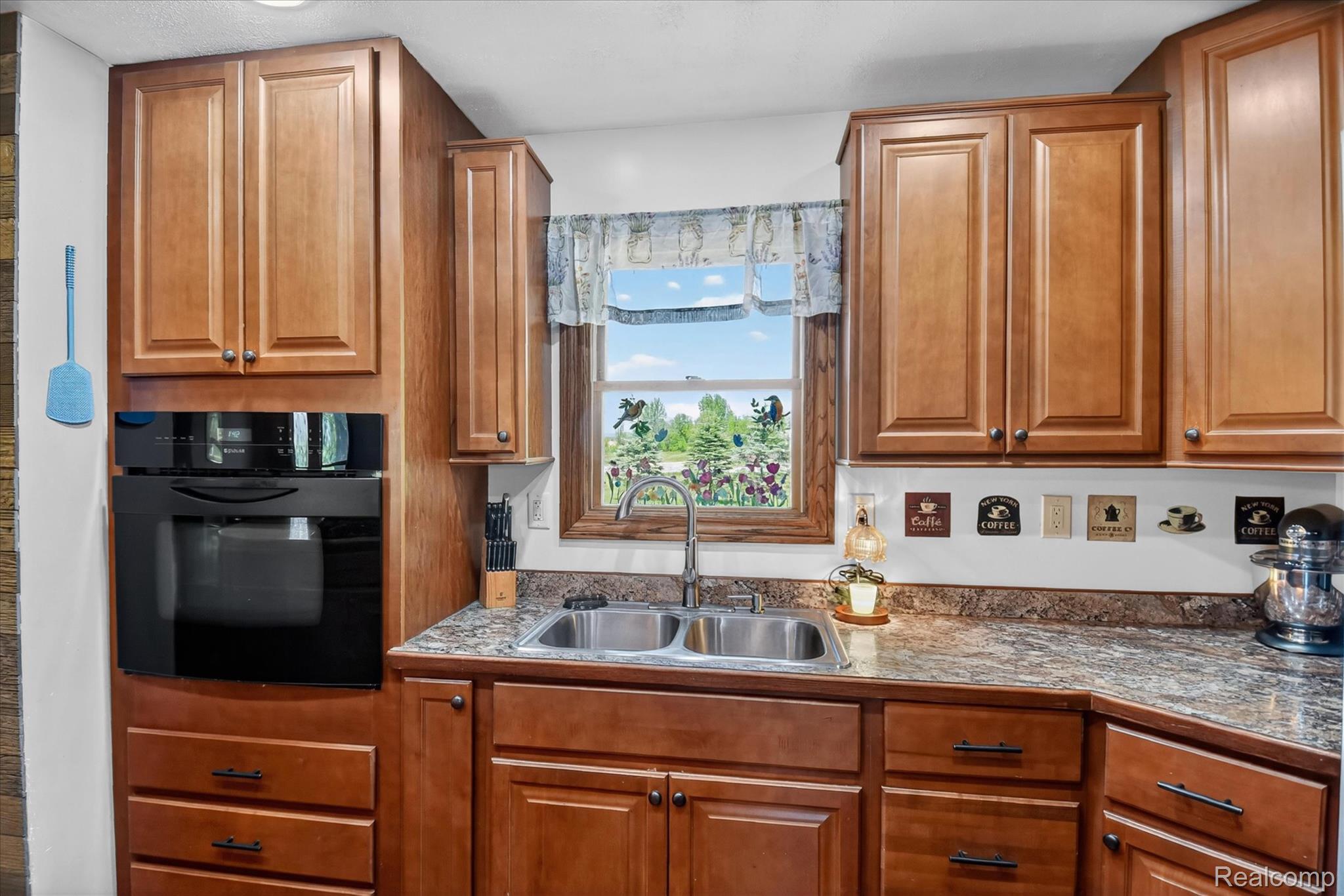 3949 West Burns Line Road Brown City, MI 48416 - Photo 18 of 70 Kitchen featuring wood cabinetry, a stainless steel double basin sink, a built-in wall oven, and variegated countertops