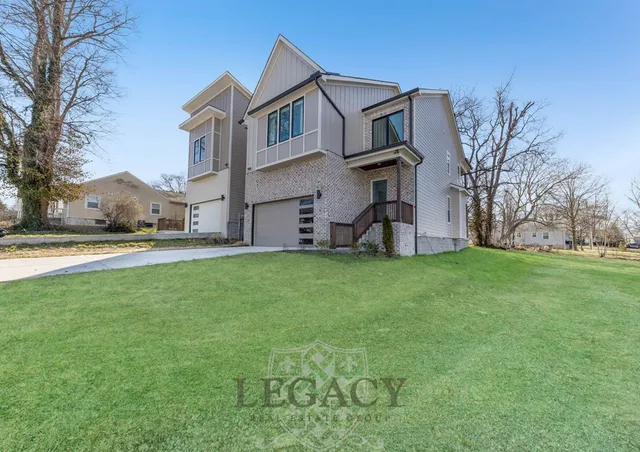 a view of a big house with a big yard and large trees