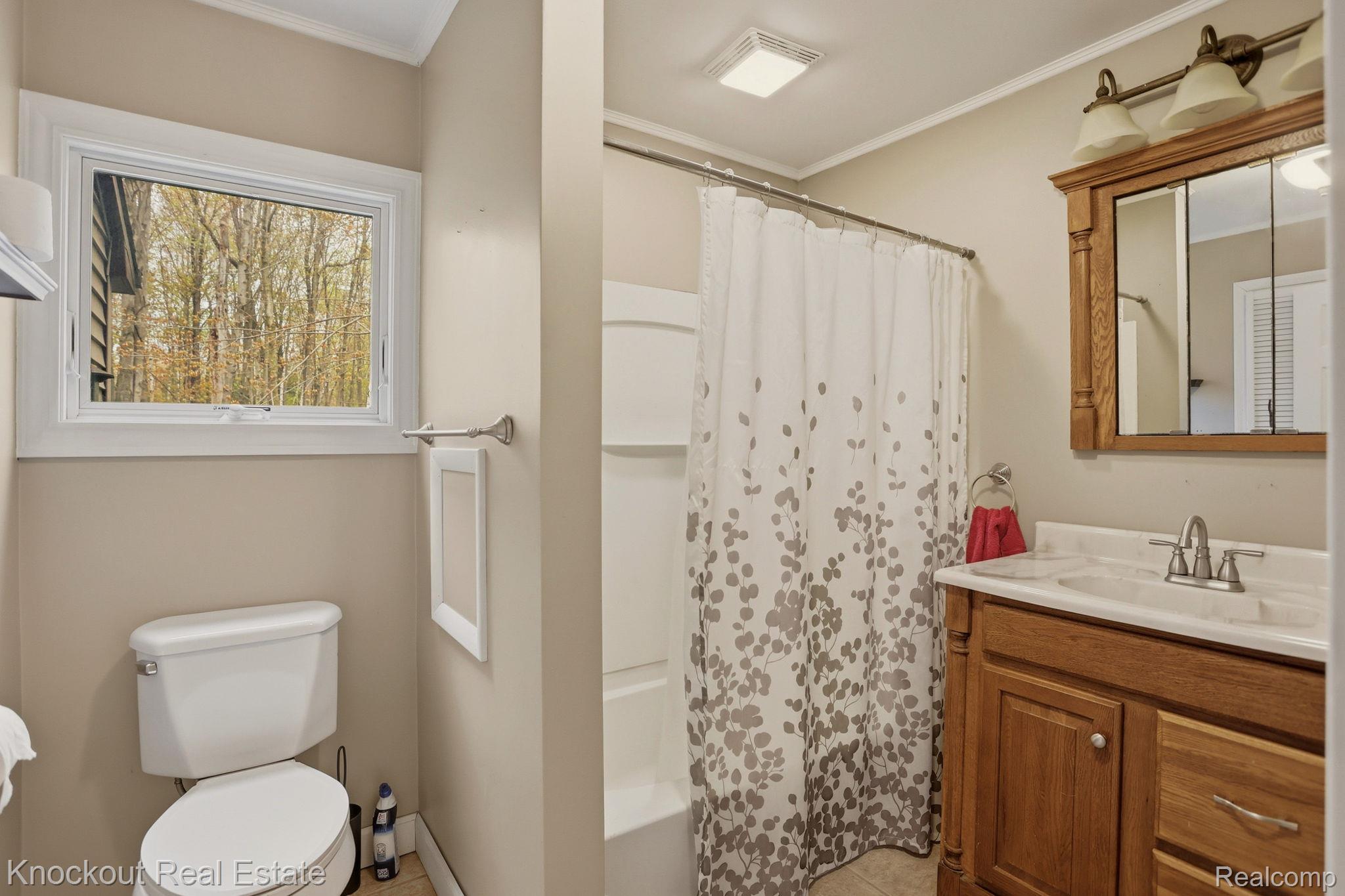 1608 South Pinnebog Road Bad Axe, MI 48413 - Photo 25 of 54 Bathroom with vanity, crown molding, and shower / tub combo
