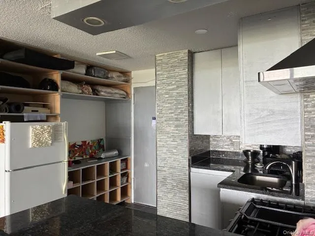 a kitchen with stainless steel appliances kitchen island granite countertop a refrigerator and a stove