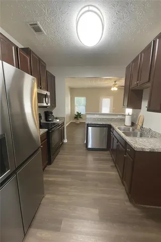 a large kitchen with stainless steel appliances granite countertop a refrigerator and a sink