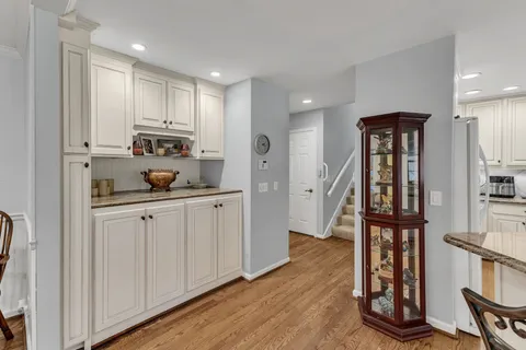 a kitchen with white cabinets and window