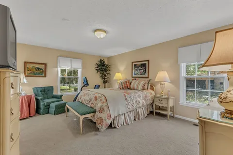 a bedroom with bed and a large window