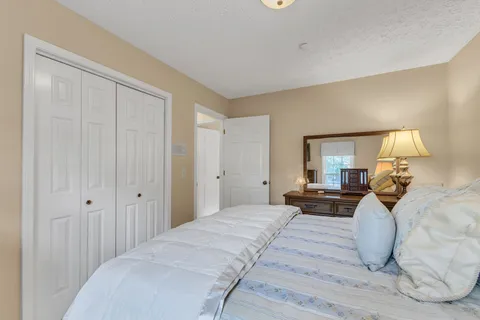 a bedroom with a large bed and wooden floor