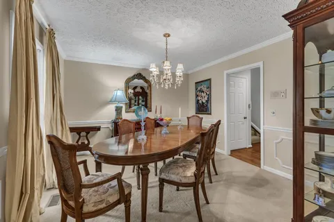 a view of a dining room with furniture and a chandelier