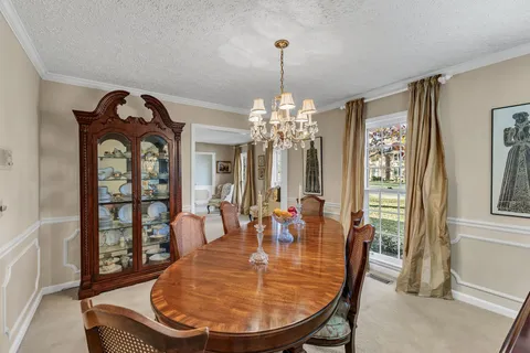 a view of a dining room with furniture and chandelier