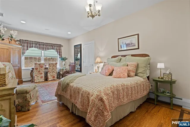 a large bedroom with bed and wooden floor