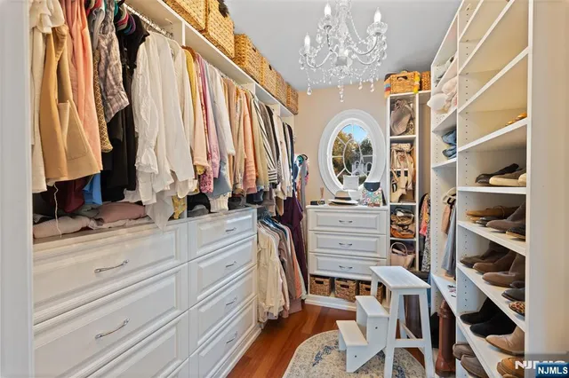 a view of walk in closet with clothes and shoes