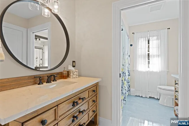 a bathroom with a sink a toilet and a mirror