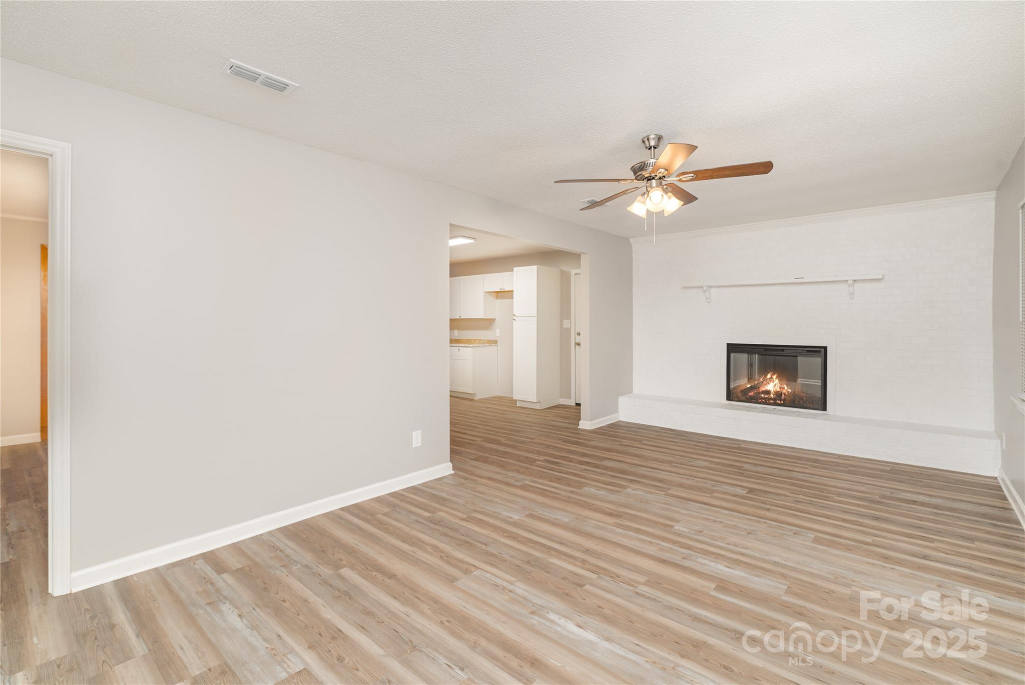 1041 Crowders Creek Road Gastonia, NC 28052 - Photo 2 of 18 a view of an empty room with chandelier fan and wooden floor