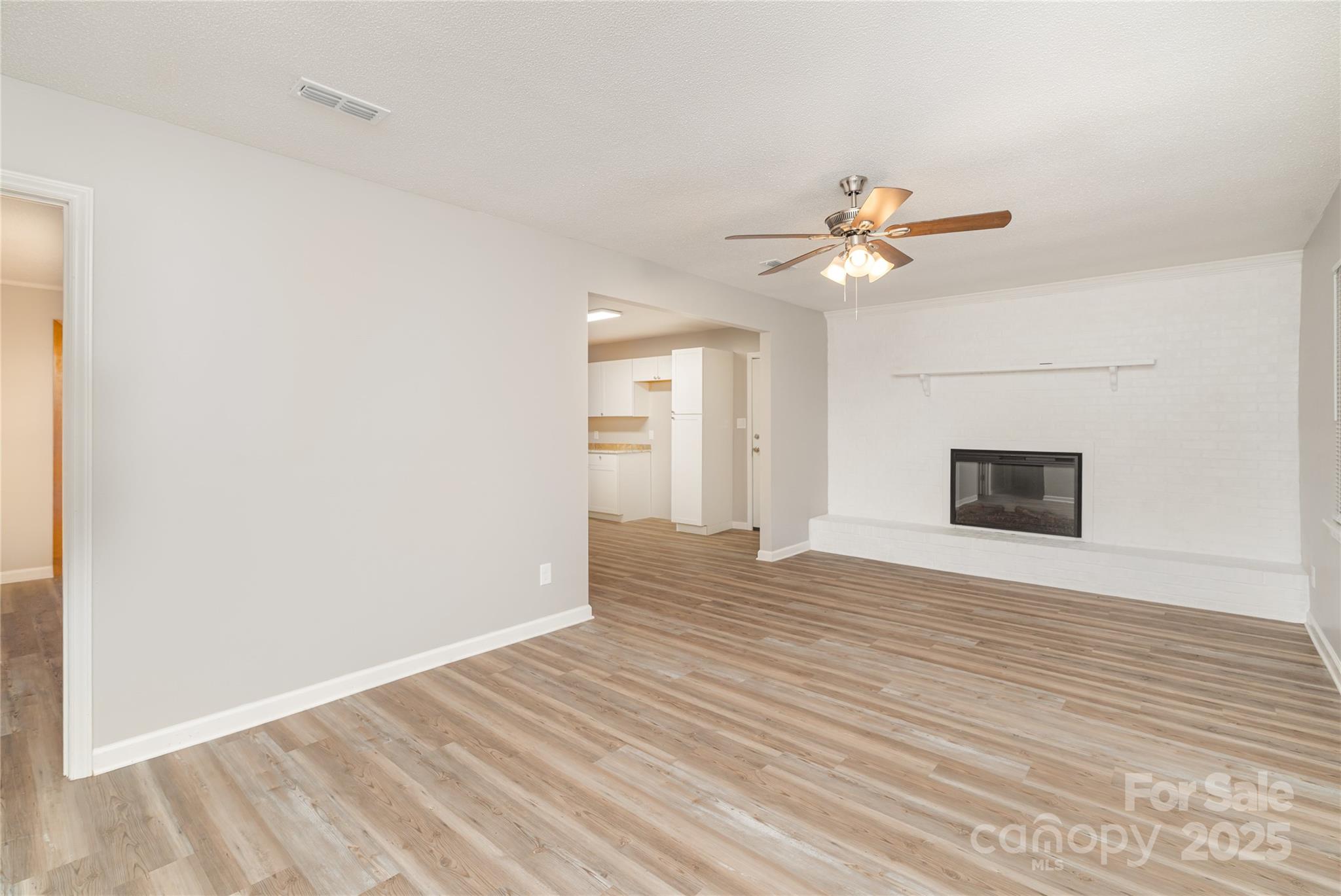 1041 Crowders Creek Road Gastonia, NC 28052 - Photo 7 of 18 a view of an empty room with chandelier fan and wooden floor