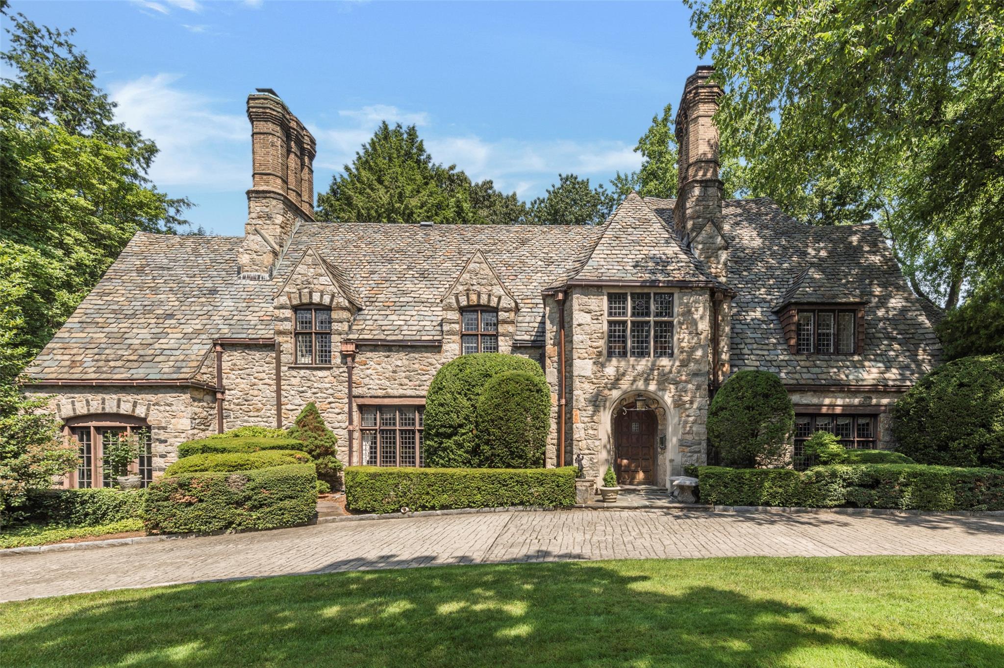 9 Rittenhouse Road Bronxville, NY 10708 - Photo 1 of 32 Tudor house featuring a front lawn, stone siding, a chimney, and a high end roof