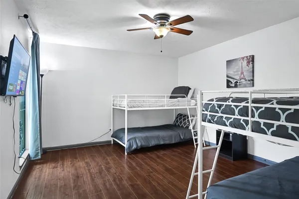 a view of room with wooden floor and ceiling fan