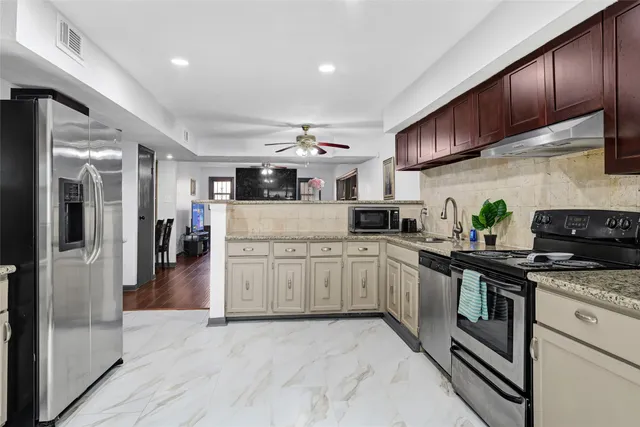 a kitchen with stainless steel appliances granite countertop a refrigerator and a sink