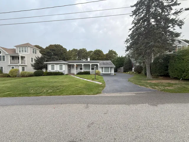 a view of a house with a big yard and large trees
