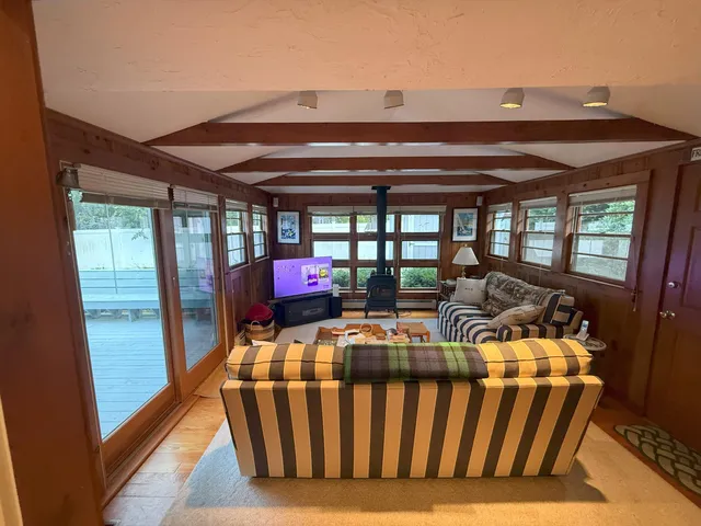 a living room with furniture fireplace and a large window