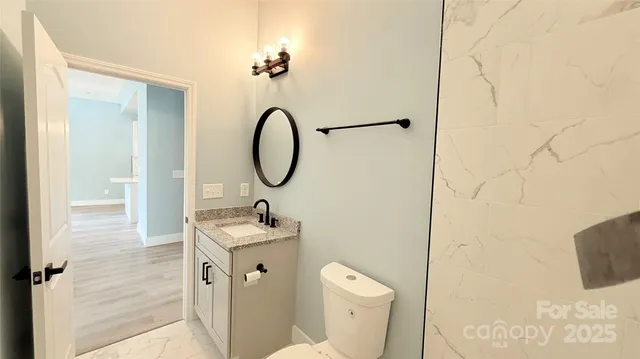 a bathroom with a sink and mirror with toilet