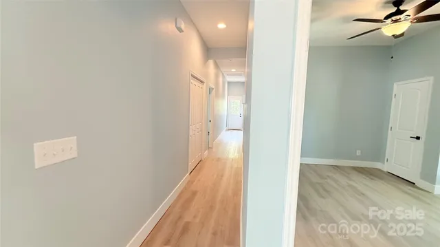 a view of a hallway with wooden floor