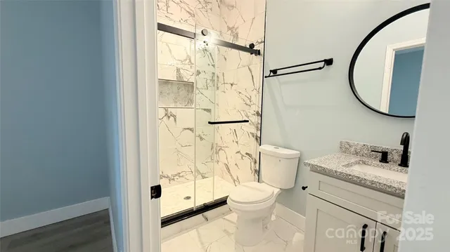 a bathroom with a granite countertop sink toilet and shower