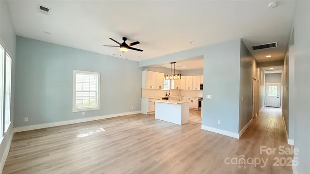 a view of a large kitchen with wooden floor and a kitchen