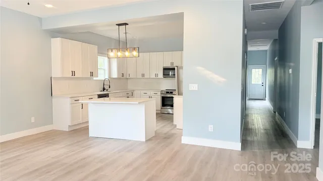 a kitchen with white cabinets and white appliances
