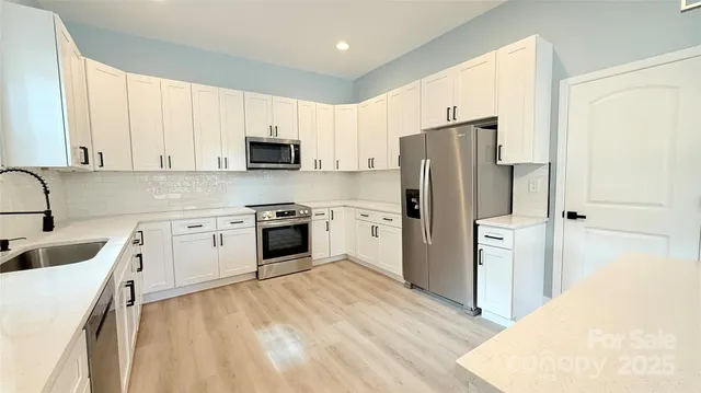 a kitchen with a refrigerator sink and wooden cabinets