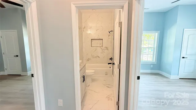 an empty room that has a wooden door mirror and shower
