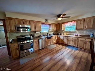 1465 Derby Road Waterford, OH 45786 - Photo 6 of 20 Kitchen featuring dark hardwood / wood-style flooring, ceiling fan, stainless steel appliances, and backsplash