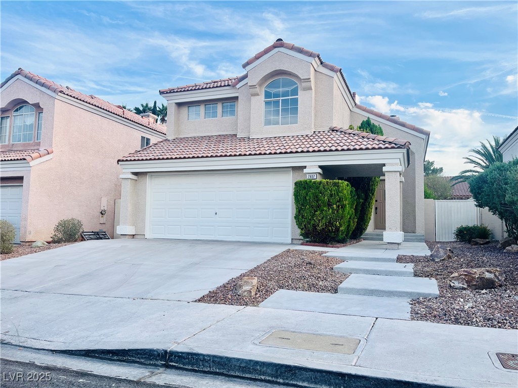 Mediterranean / spanish home featuring stucco siding, concrete driveway, a garage, and a tiled roof