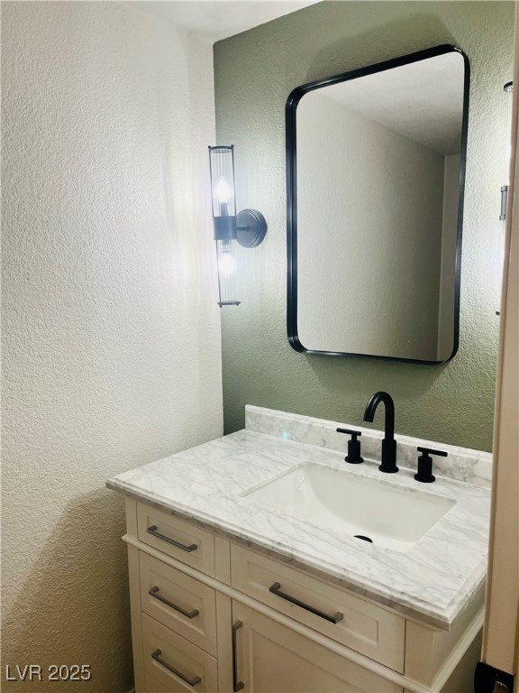 7837 Millhopper Avenue Las Vegas, NV 89128 - Photo 13 of 28 Bathroom with a textured wall and vanity