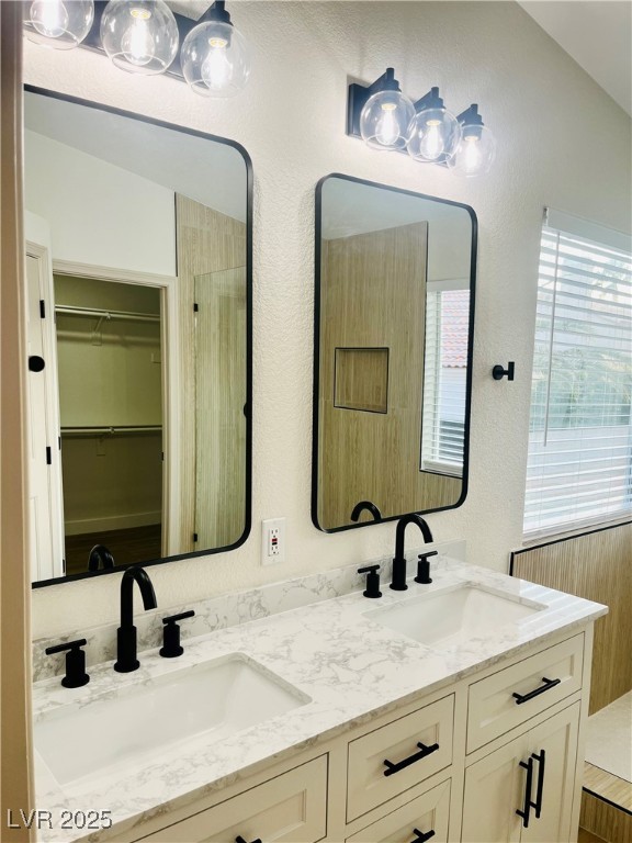 7837 Millhopper Avenue Las Vegas, NV 89128 - Photo 17 of 28 Full bath with a textured wall, double vanity, a spacious closet, and tiled shower