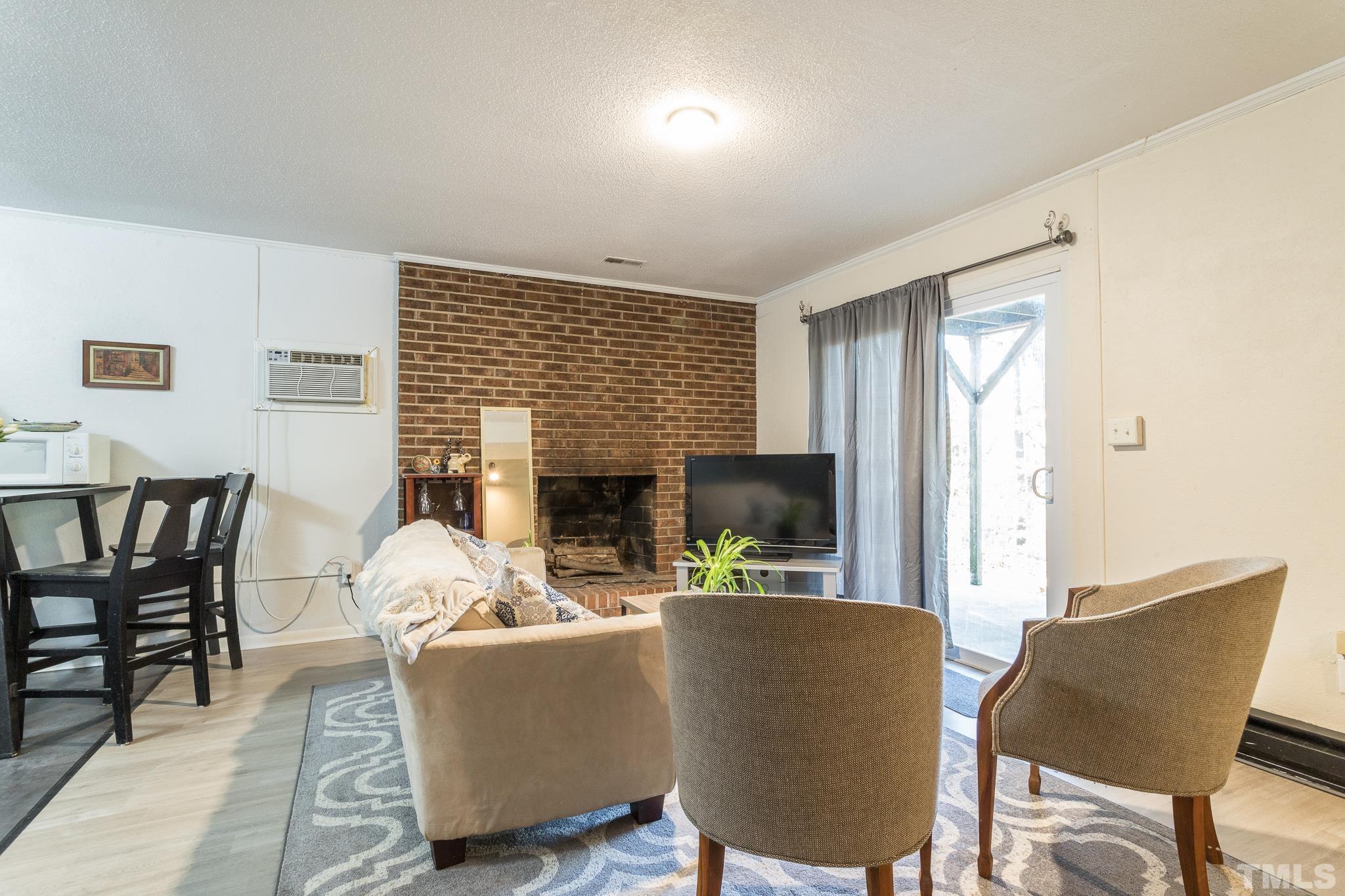 372 Cedar Lake Road Chapel Hill, NC 27516 - Photo 35 of 42 a living room with furniture a fireplace and a table