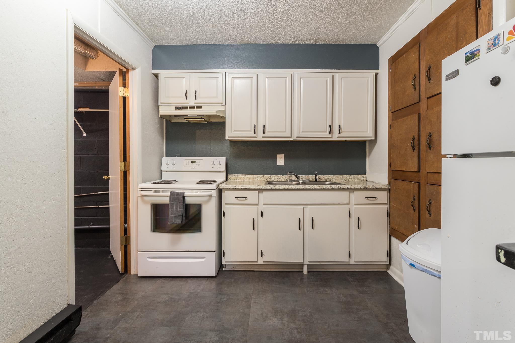 372 Cedar Lake Road Chapel Hill, NC 27516 - Photo 37 of 42 a kitchen with a white stove and white cabinets