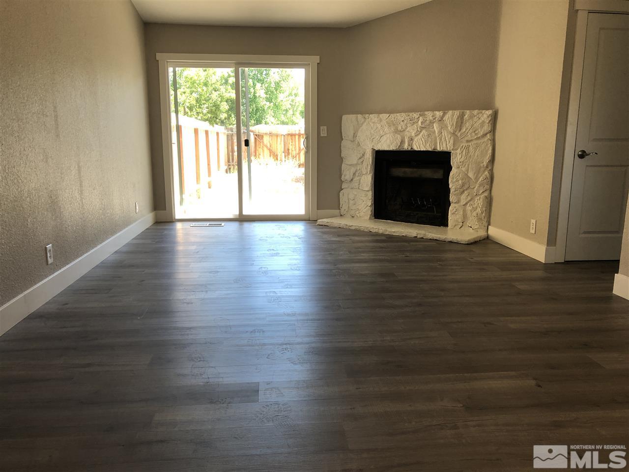 10028 Humite Lane Reno, NV 89506 - Photo 5 of 9 a view of an empty room with wooden floor and a window