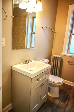 a bathroom with a sink a toilet and a mirror
